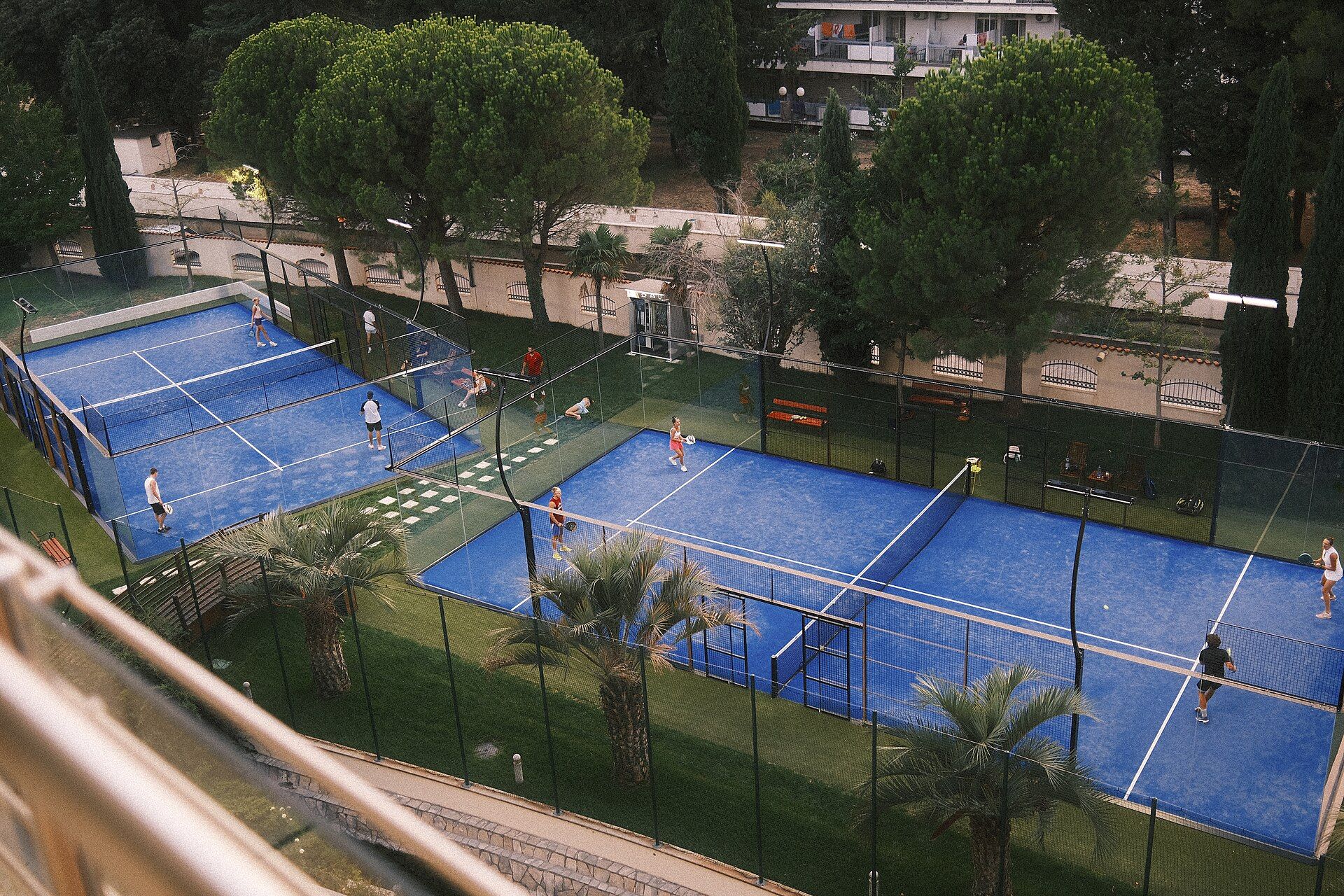 Joueurs de padel en pleine partie sur des terrains bleus